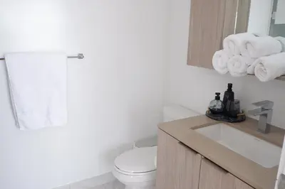 a bathroom with a toilet and a sink and towels at Modern luxury Waterfront Condo in Mississauga
