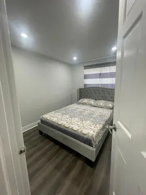 a small bedroom with a bed in a room at Mo's Place in Mississauga