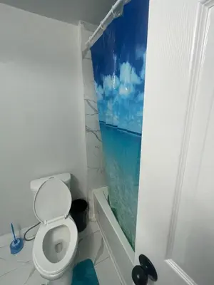 a bathroom with a toilet and a window at Mo's Place in Mississauga