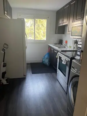 a kitchen with a refrigerator and a stove top oven at Mo's Place in Mississauga