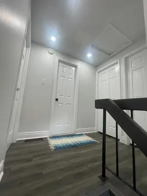 an empty hallway with a white door and a staircase at Mo's Place in Mississauga