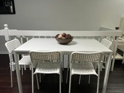 a white table with chairs and a bowl of fruit on it at Bright, Private, Peaceful Suite with Retail Conveniences Steps Away in Toronto