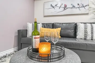 a bottle of wine and two wine glasses on a table at Modern 2BR on Queensway, Kitchen, Parking, 20 Mins from CNT and YYZ in Toronto