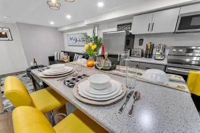 a kitchen with a table and yellow chairs at Modern 2BR on Queensway, Kitchen, Parking, 20 Mins from CNT and YYZ in Toronto