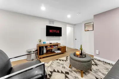 a living room with a tv and a couch at Modern 2BR on Queensway, Kitchen, Parking, 20 Mins from CNT and YYZ in Toronto
