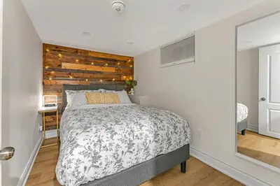 a bedroom with a bed and a wooden wall at Modern 2BR on Queensway, Kitchen, Parking, 20 Mins from CNT and YYZ in Toronto