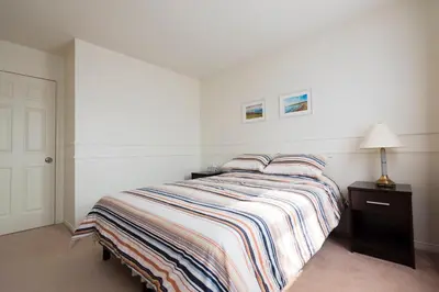 a bedroom with a bed with a striped comforter at The Comfort Stay at City of Pickering in Pickering