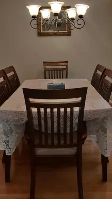 a dining room table with a tablecloth and a chair at The Comfort Stay at City of Pickering in Pickering