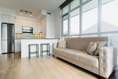 a living room with a couch and a kitchen at Cozy & Contemporary Suite - Easy Access to Everything in Richmond Hill