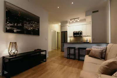 a living room with a couch and a kitchen at Cozy & Contemporary Suite - Easy Access to Everything in Richmond Hill