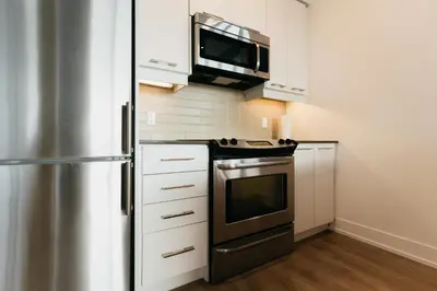 a kitchen with a stainless steel refrigerator and a microwave at Cozy & Contemporary Suite - Easy Access to Everything in Richmond Hill