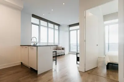 a kitchen and living room with windows and a bed at Cozy & Contemporary Suite - Easy Access to Everything in Richmond Hill