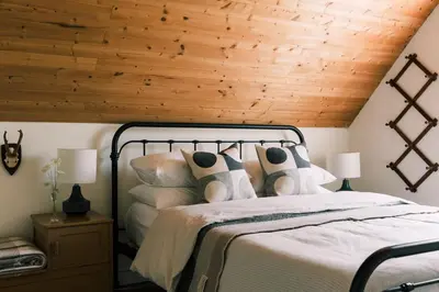 a bedroom with a bed with a wooden ceiling at The Beachside Burrow - Next to Sandbanks w Hot Tub in West Lake