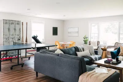 a living room with couches and a ping pong table at The Beachside Burrow - Next to Sandbanks w Hot Tub in West Lake