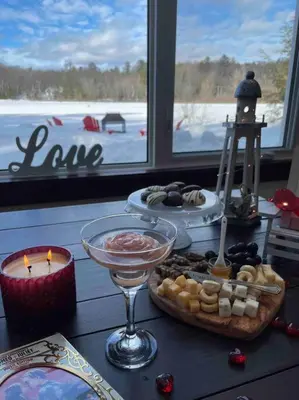 a table with some food and candles and a window at Four Season Waterfront Muskoka Retreat in Bracebridge