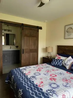 a bedroom with a bed with a blue and white quilt at Four Season Waterfront Muskoka Retreat in Bracebridge