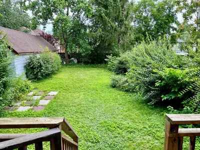 a backyard with a wooden fence and a yard withgrass at Victoria Family Vacation Home - King Bed Private Yard BBQ Deck Gazebo - 4 Minutes To The Falls in Niagara Falls