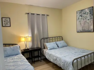 a bedroom with two beds and a table with a lamp at Victoria Family Vacation Home - King Bed Private Yard BBQ Deck Gazebo - 4 Minutes To The Falls in Niagara Falls