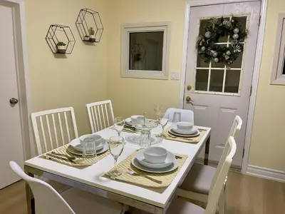 a dining room with a white table and chairs at Victoria Family Vacation Home - King Bed Private Yard BBQ Deck Gazebo - 4 Minutes To The Falls in Niagara Falls