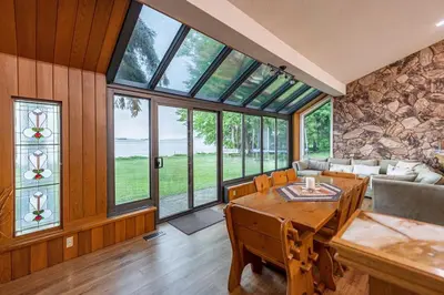 a living room with a table and some windows at Waterfront - Kawartha Lakes in Kawartha Lakes