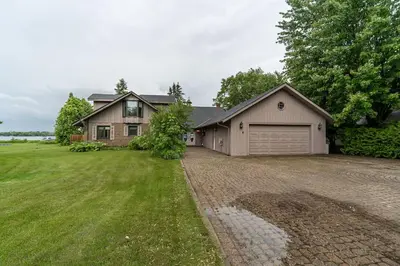 a house with a garage and a grass yard at Waterfront - Kawartha Lakes in Kawartha Lakes