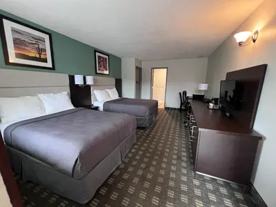 a hotel room with two beds and a desk at Wellington Inn in Bracebridge