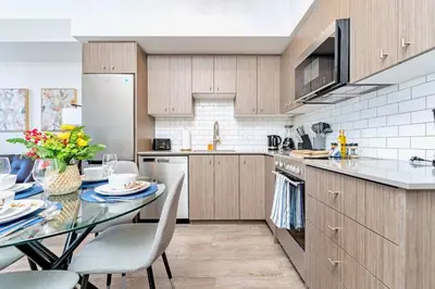 a kitchen with a table with chairs and a counter top at Union Towers Condo with City Views and Patio in Kitchener