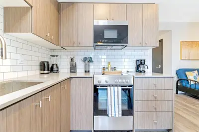 a kitchen with a stove and a microwave at Union Towers Condo with City Views and Patio in Kitchener
