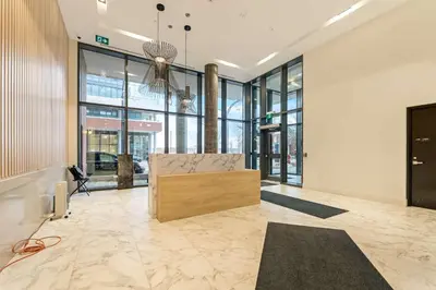 a lobby with a couch in a room with windows at Union Towers Condo with City Views and Patio in Kitchener