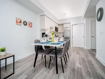 a dining room and kitchen with a table and chairs at Modern 1BR Condo - King bed - Cityscape Views in Kitchener