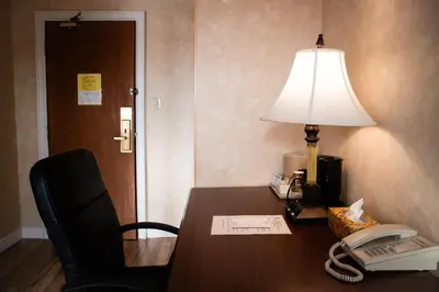 a desk with a lamp and a telephone and a phone at Royal Inn and Suites at Guelph in Guelph