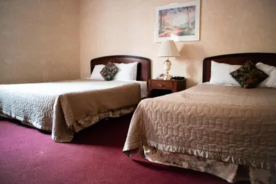 a hotel room with two beds and a lamp at Royal Inn and Suites at Guelph in Guelph