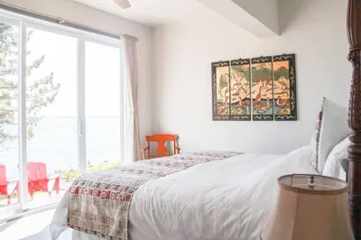 a bedroom with a bed and a large window at SkyTime Vacations in Wellington