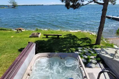 a jacuzzi tub with a dog walking by the water at SkyTime Vacations in Wellington