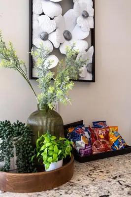 a vase with flowers in it on a table with snacks at Ultra Luxurious 2.5 Bedroom 2 Full Bathroom 1 Parking Condo Near SQ1 Striking Views in Mississauga