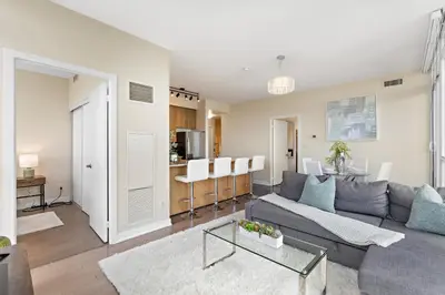 a living room with a couch and a table at Ultra Luxurious 2.5 Bedroom 2 Full Bathroom 1 Parking Condo Near SQ1 Striking Views in Mississauga