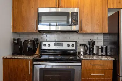 a kitchen with a stove and a microwave at Ultra Luxurious 2.5 Bedroom 2 Full Bathroom 1 Parking Condo Near SQ1 Striking Views in Mississauga