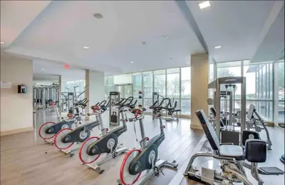 a gym with a lot of treadmills and ellipticals at Ultra Luxurious 2.5 Bedroom 2 Full Bathroom 1 Parking Condo Near SQ1 Striking Views in Mississauga