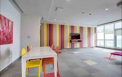 a room with a table and chairs and a tv at Ultra Luxurious 2.5 Bedroom 2 Full Bathroom 1 Parking Condo Near SQ1 Striking Views in Mississauga