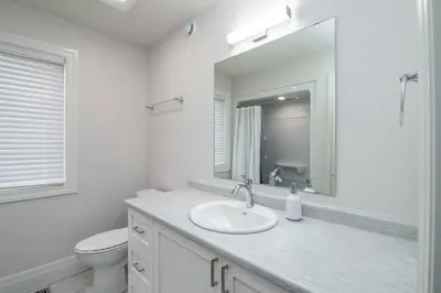 a bathroom with a sink and a toilet and a mirror at Stylish House W a Media Room Near Downtown Picton in Picton