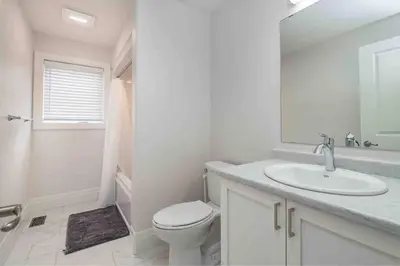 a white bathroom with a toilet and a sink at Stylish House W a Media Room Near Downtown Picton in Picton