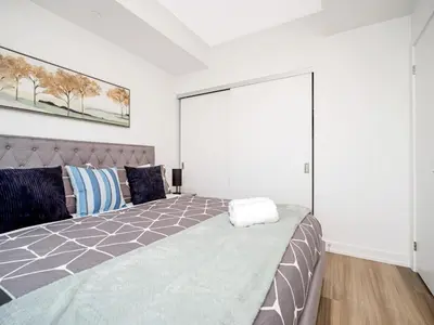 a bedroom with a bed with a large sliding door at City View 1BR Condo - King Bed & Private Balcony in Kitchener