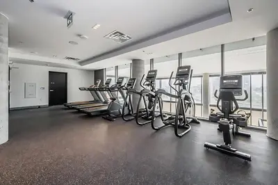 a gym with a row of exercise bikes and treadmills at City View 1BR Condo - King Bed & Private Balcony in Kitchener