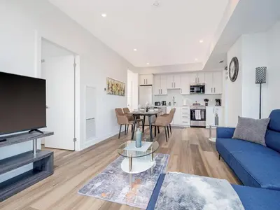 a living room with a blue couch and a table at City View 1BR Condo - King Bed & Private Balcony in Kitchener