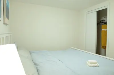 a white bed with a towel on it in front of a mirror at Spacious 2-Bed-Room near Yonge & Major Mackenzie in Richmond Hill