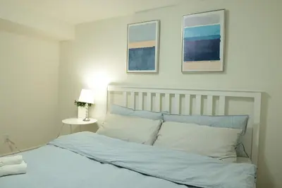 a bedroom with a bed with two pictures on the wall at Spacious 2-Bed-Room near Yonge & Major Mackenzie in Richmond Hill