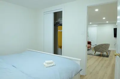 a bedroom with a white bed and a mirror at Spacious 2-Bed-Room near Yonge & Major Mackenzie in Richmond Hill
