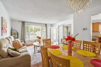 a dining room and living room with a table and chairs at Glengarry Haus Spacious 2BR Home Away From Home in Mississauga