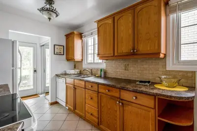 a kitchen with wooden cabinets and a counter top at Glengarry Haus Spacious 2BR Home Away From Home in Mississauga