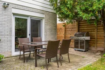 a patio with a table and chairs and a grill at Glengarry Haus Spacious 2BR Home Away From Home in Mississauga
